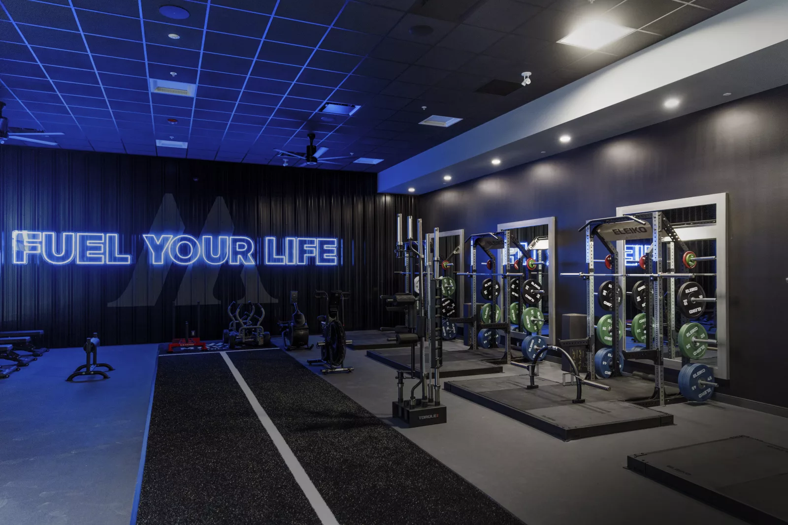 Exercise for seniors in a modern gym setting with motivational posters and exercise equipment.