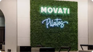 Wall Pilates workouts in a modern gym with Pilates reformer machines under soft lighting.